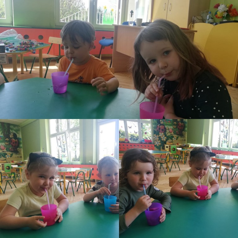 Dzieci pijące wodę przez słomki z kolorowych kubków