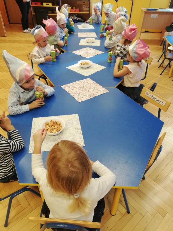 Dzieci siedzą przy stole w przedszkolu
