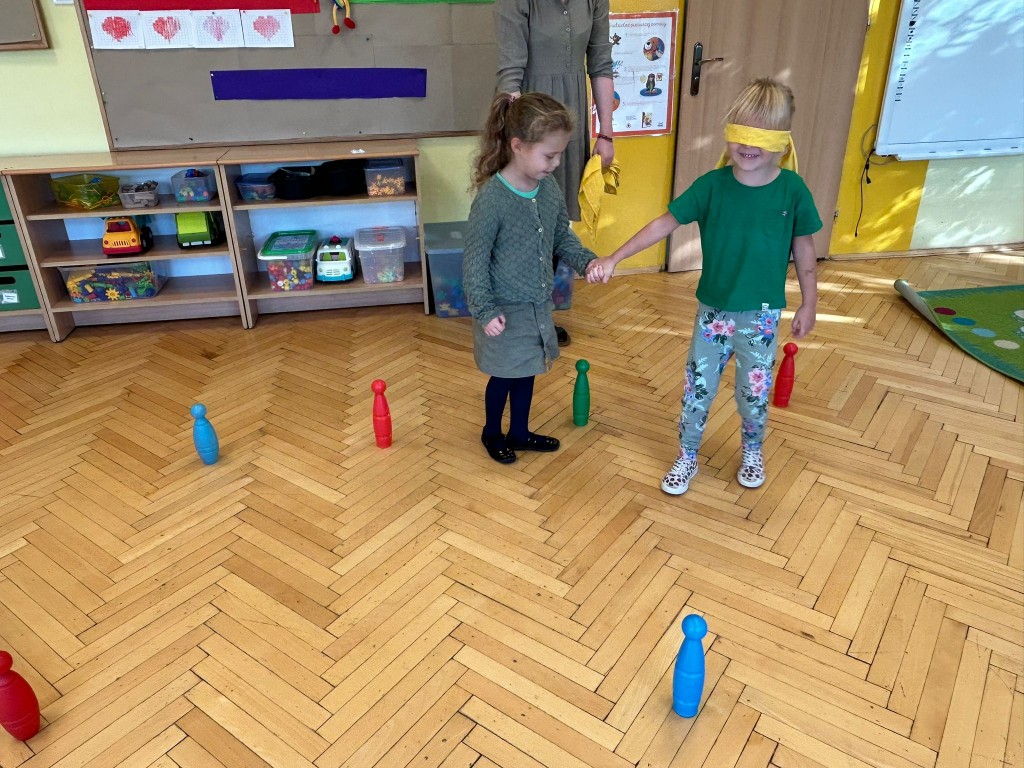 Dzieci ćwiczą prowadzenie osoby niewidomej.
