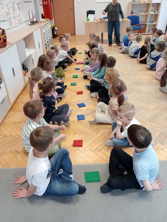 Dzieci z woreczkami siedzą na podłodze