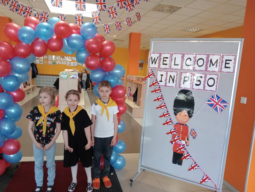 trójka dzieci przy banerze Welcome in P50