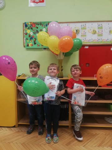 Trzech chłopców z kolorowymi balonami