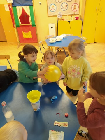 Dzieci bawią się napompowanym balonem.